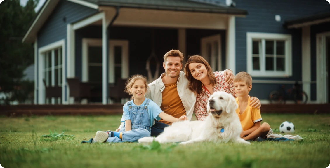 Family and dog in front of house.