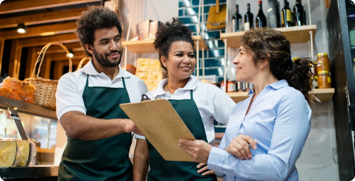 Store staff discussing with a clipboard.
