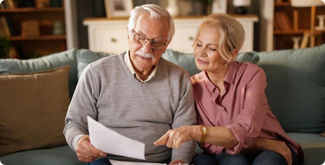 Elderly couple reviewing documents together at home.